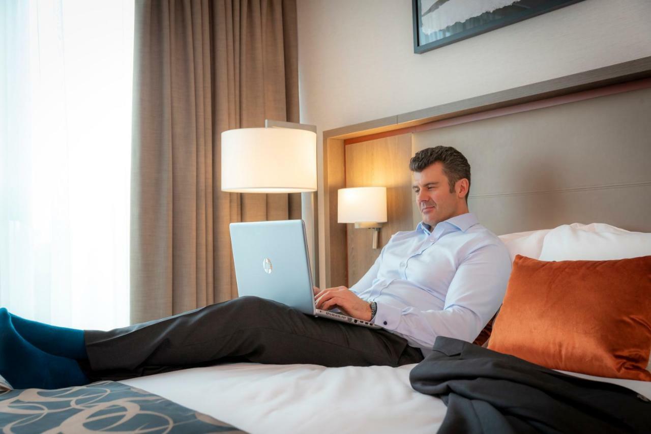 فندق كلايتون دبلن إيربورت Coolock المظهر الخارجي الصورة A man working on a laptop in a hotel room